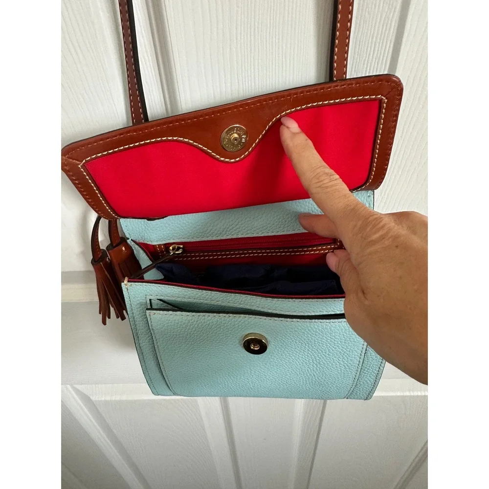 This is a Dooney & Bourke Pebble Grain East/West Flap Crossbody in a light blue